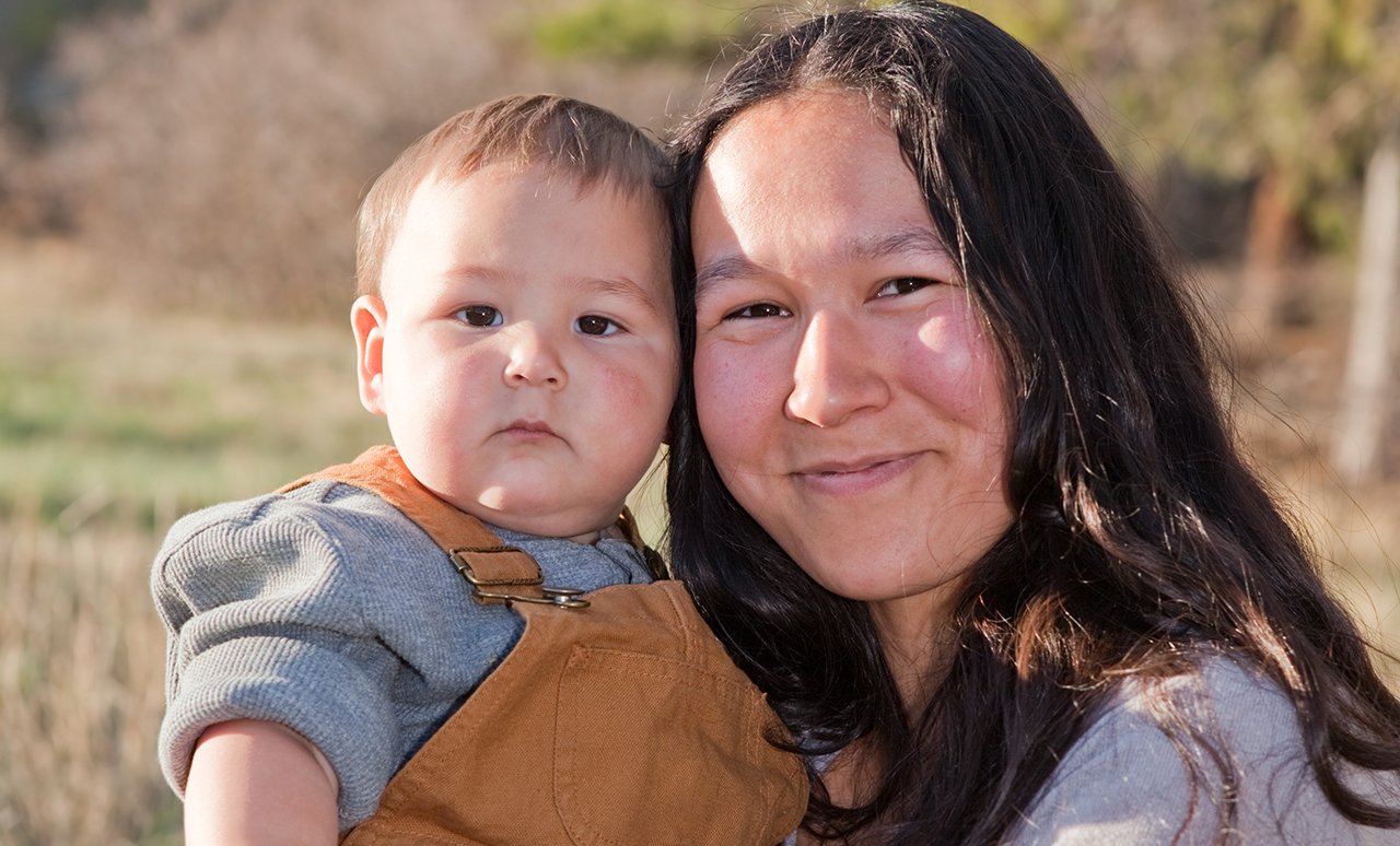 Photo of a smiling woman holding a baby